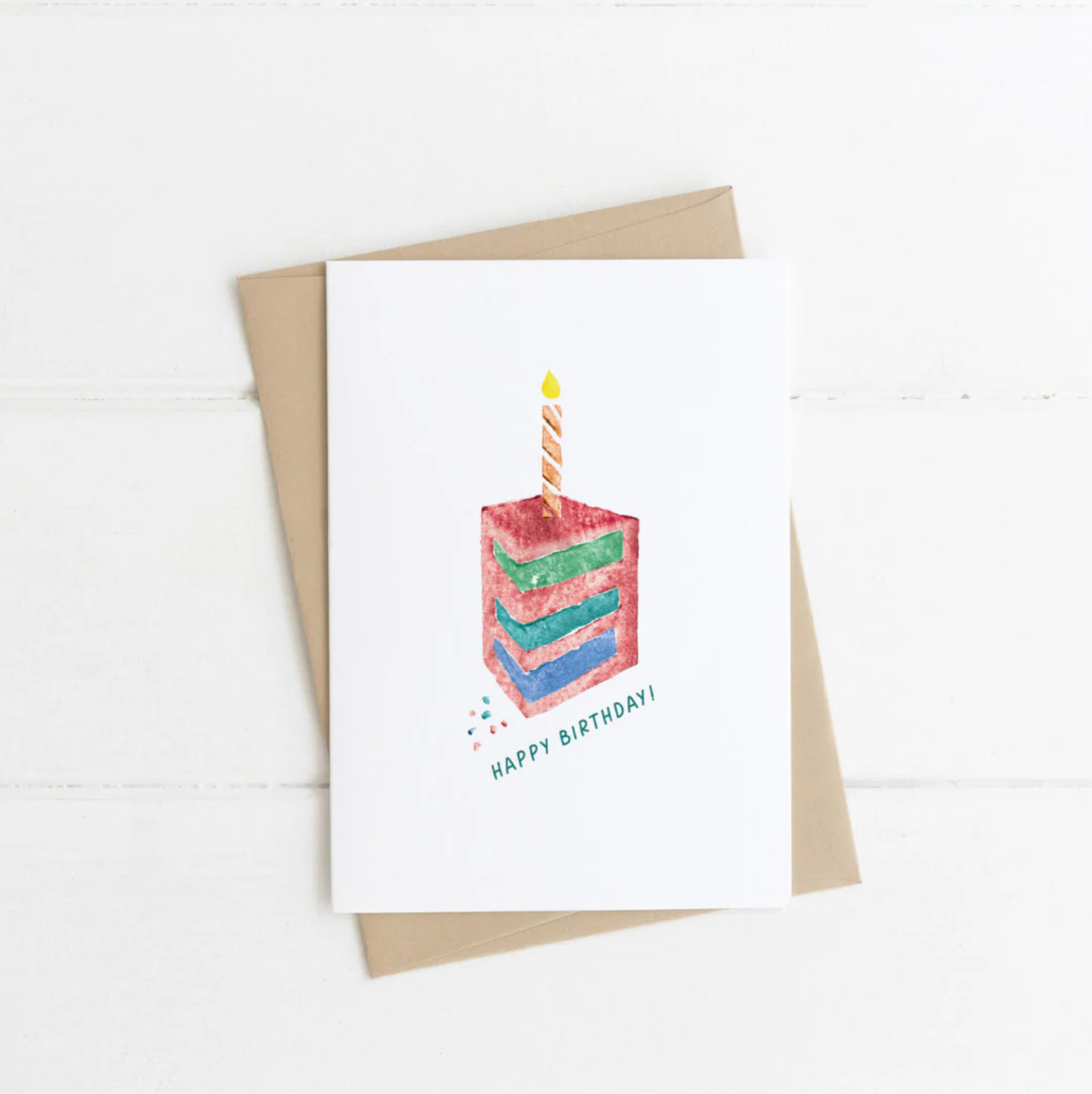 Greeting card with a colorful birthday cake illustration and 'Happy Birthday!' text, on a white background.